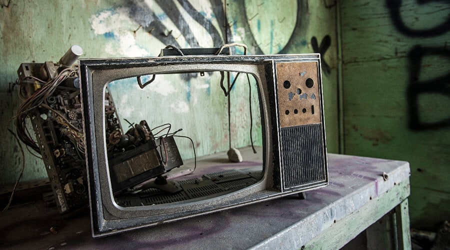 A broken old CRT TV set in a derelict building
