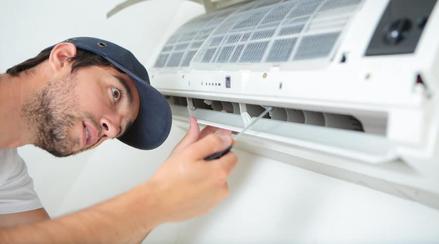 A person working on an air conditioning unit