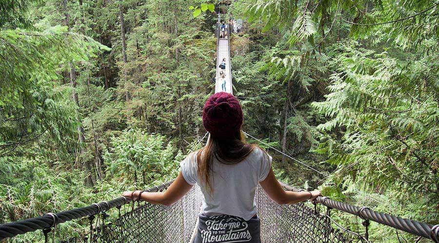 A woman standing on a rope bridge